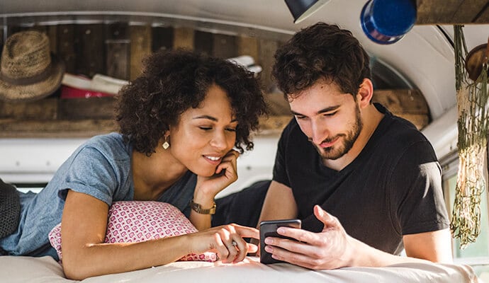 Un uomo e una donna che guardano un telefono cellulare