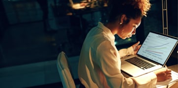 Donna seduta davanti a un computer portatile